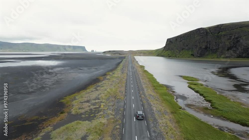 4K drone video of a road in Iceland with a car driving on it.