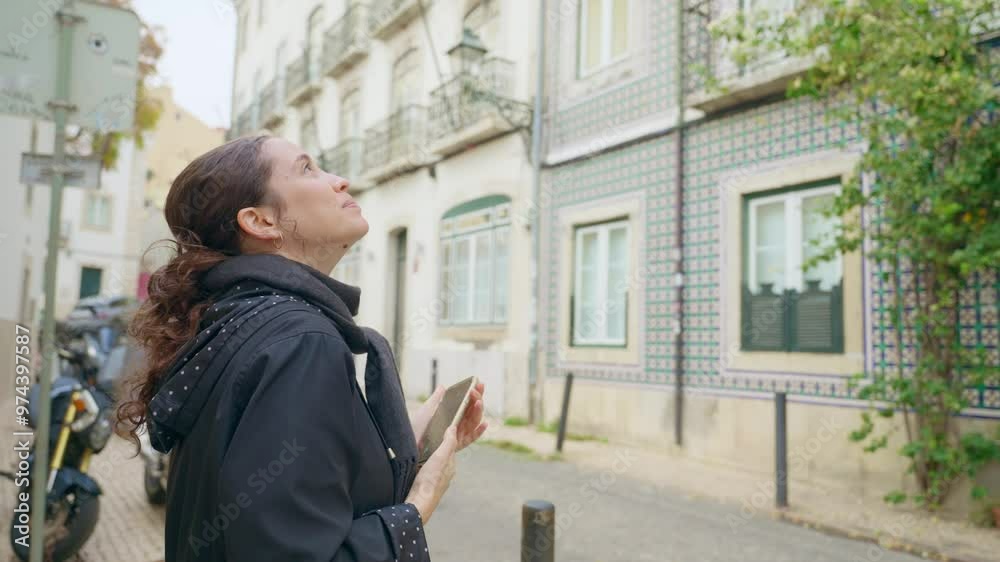Young female student or tourist taking photos with smartphone in Lisbon street. Sightseeing during summer or spring vacation. Woman enjoys beautiful local architecture design and city art in Portugal Young female student or tourist taking photos with smartphone in Lisbon street. Sightseeing during summer or spring vacation. Woman enjoys beautiful local architecture design and city art in Portugal