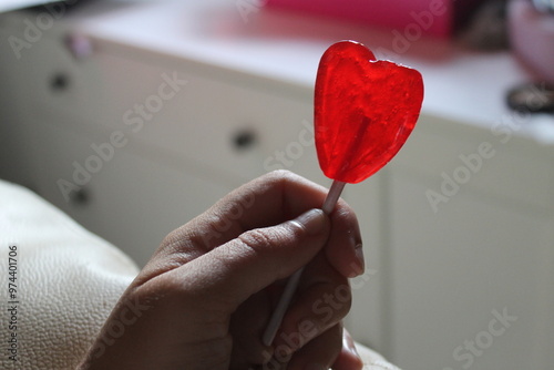 woman's hand holding a coloured lollipop