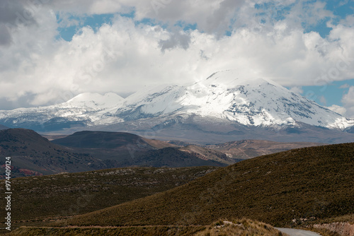 Majestic chimborazo volcano towering over a vast and rugged andean landscape, showcasing the beauty and power of nature with its snow-capped peak reaching for the cloudy sky