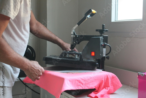 person printing a t-shirt with a thermal iron