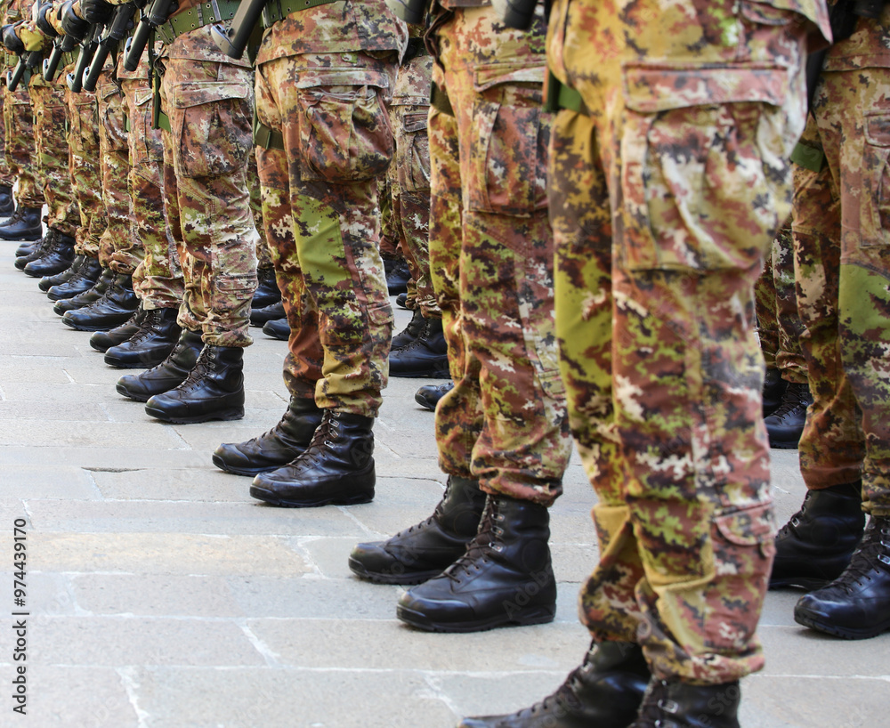 Black combat boots of army soldiers in camouflage uniforms standing in formation Black combat boots of army soldiers in camouflage uniforms standing in formation