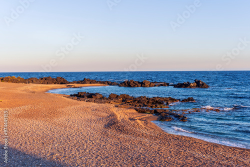 beautiful pink and orange sand beash with black stones and sea surf waves lansacspe with anazing clousy sunset or sunrise sky on background photo