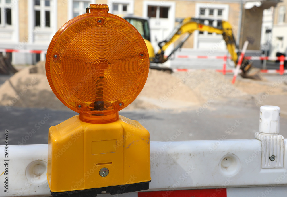 blinking orange lamp mounted on a protective barrier warns drivers of a construction zone blinking orange lamp mounted on a protective barrier warns drivers of a construction zone