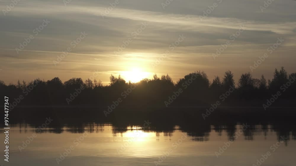 Warm summer sunrise-sunset over the northern river, calm water (breathless), but colors of an alarming sunset Warm summer sunrise-sunset over the northern river, calm water (breathless), but colors of an alarming sunset