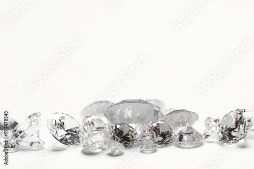 Many beautiful shiny diamonds on white background, closeup. Space for text