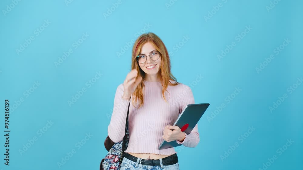 A confident and energetic young woman proudly holds a sleek and modern laptop against a bright blue background, radiating an infectious excitement and vibrant energy for the future ahead A confident and energetic young woman proudly holds a sleek and modern laptop against a bright blue background, radiating an infectious excitement and vibrant energy for the future ahead