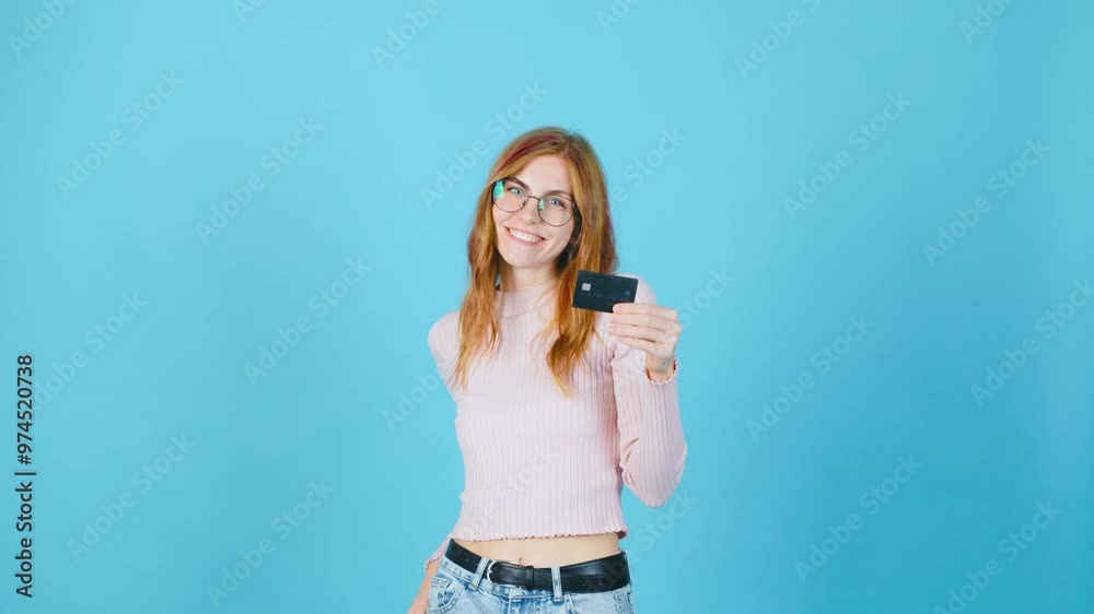 A young woman confidently holds a credit card against a vibrant blue background, showcasing her unique style and lifestyle while embracing modern finance and consumerism A young woman confidently holds a credit card against a vibrant blue background, showcasing her unique style and lifestyle while embracing modern finance and consumerism