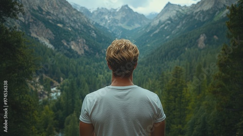 Mock-up of a man wearing a plain t-shirt from behind, with a mountain forest and dense green trees in the background