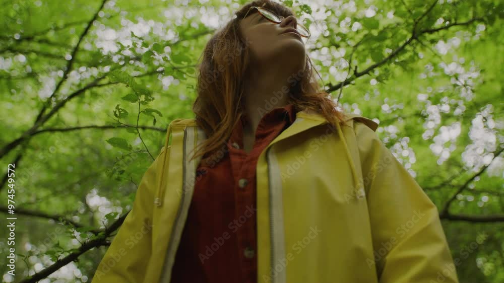 Ginger woman with yellow raincoat with glasses in forest Ginger woman with yellow raincoat with glasses in forest