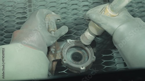 Close up cleaning and removing rust from car detail using a sandblasting machine