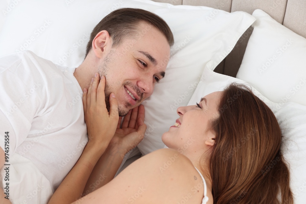 Cute couple lying on bed at home Cute couple lying on bed at home