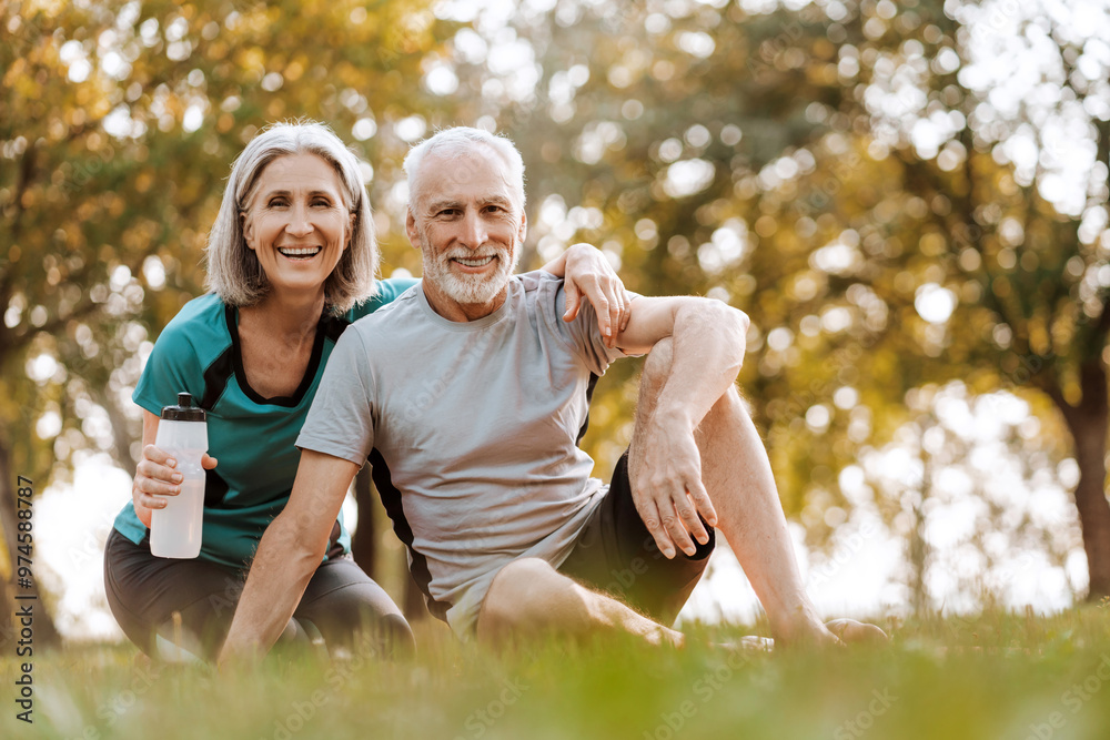 Fototapeta premium Happy senior couple relaxing in park after exercising together, hugging together