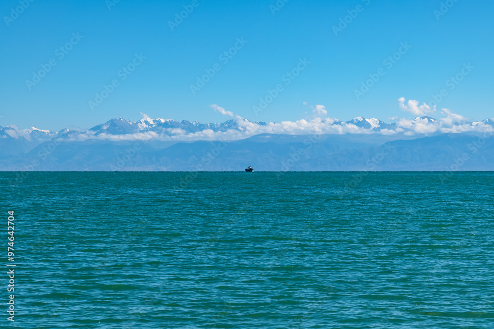 Panoramic view of Lake Issyk-Kul in Kyrgyzstan.A small ship on the horizon. Panoramic view of Lake Issyk-Kul in Kyrgyzstan.A small ship on the horizon.