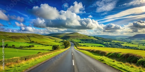 Spectacular green Welsh landscape with an asphalt roadway, under a blue sky and clouds, Wales, rural, countryside, scenery