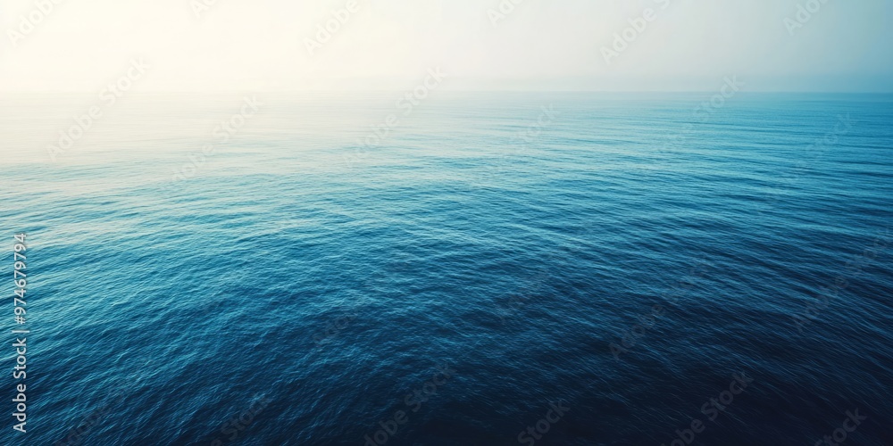 Obraz premium Aerial View of Calm Blue Ocean Waters, Showcasing the Tranquil Gradient from Deep Blue to Turquoise. A Serene and Expansive Scene that Captures the Peaceful Beauty of the Sea, Ideal for Nature, Travel