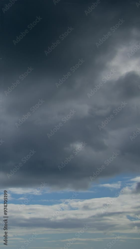 The sky is characterized by a dominant layer of gray clouds, with a few white clouds scattered above, creating a contrast in lightness and shade. The sky is characterized by a dominant layer of gray clouds, with a few white clouds scattered above, creating a contrast in lightness and shade.
