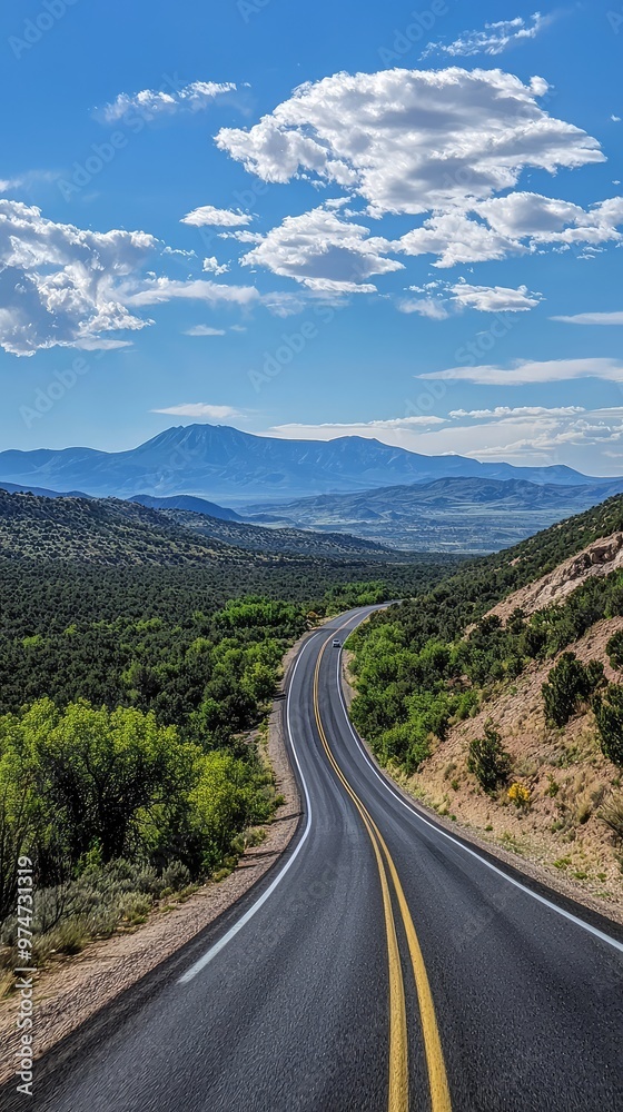 A Winding Road Through Rolling Hills, Leading to a Distant Mountain Range Under a Blue Sky A Winding Road Through Rolling Hills, Leading to a Distant Mountain Range Under a Blue Sky