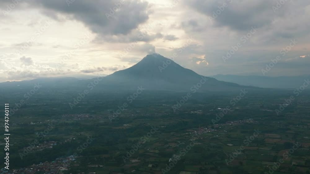 Aerial view of farmland and active Sinabung volcano. Agricultural landscape in Sumatra. Berastagi, Indonesia. Aerial view of farmland and active Sinabung volcano. Agricultural landscape in Sumatra. Berastagi, Indonesia.