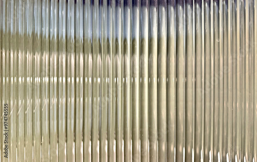 Texture of fluted glass, or striped glass, with the refraction of lights behind it. Fluted glass is aesthetically beautiful in interior finishes and used for doors and partition. Seamless fluted glass