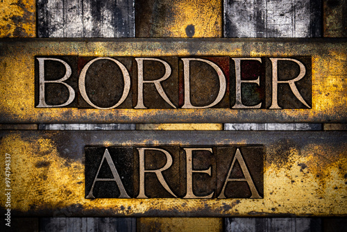 Border Area text in real authentic typeset letters on vintage textured silver grunge copper and gold background