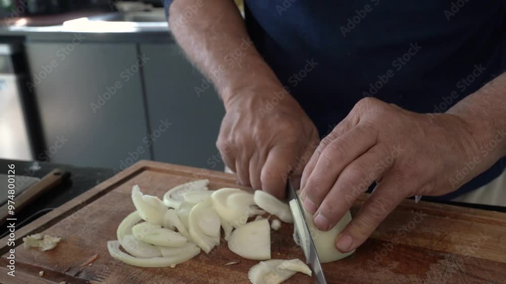 Lifestyle. Closeup view of an old man hands slicing an onion with a knife and a cutting board.