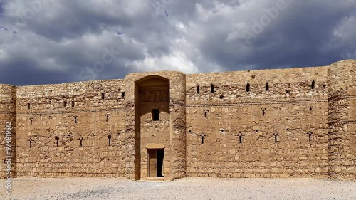 Qasr Kharana (Kharanah or Harrana)-- desert castle in eastern Jordan (100 km of Amman). Built in 8th century AD to be used as caravanserai. Against the sky with clouds. 4K, time lapse, zoom   photo