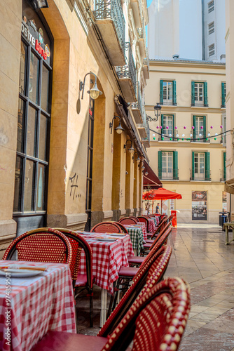 malaga old town architecture details during day hour, empty restaurant tables with no people