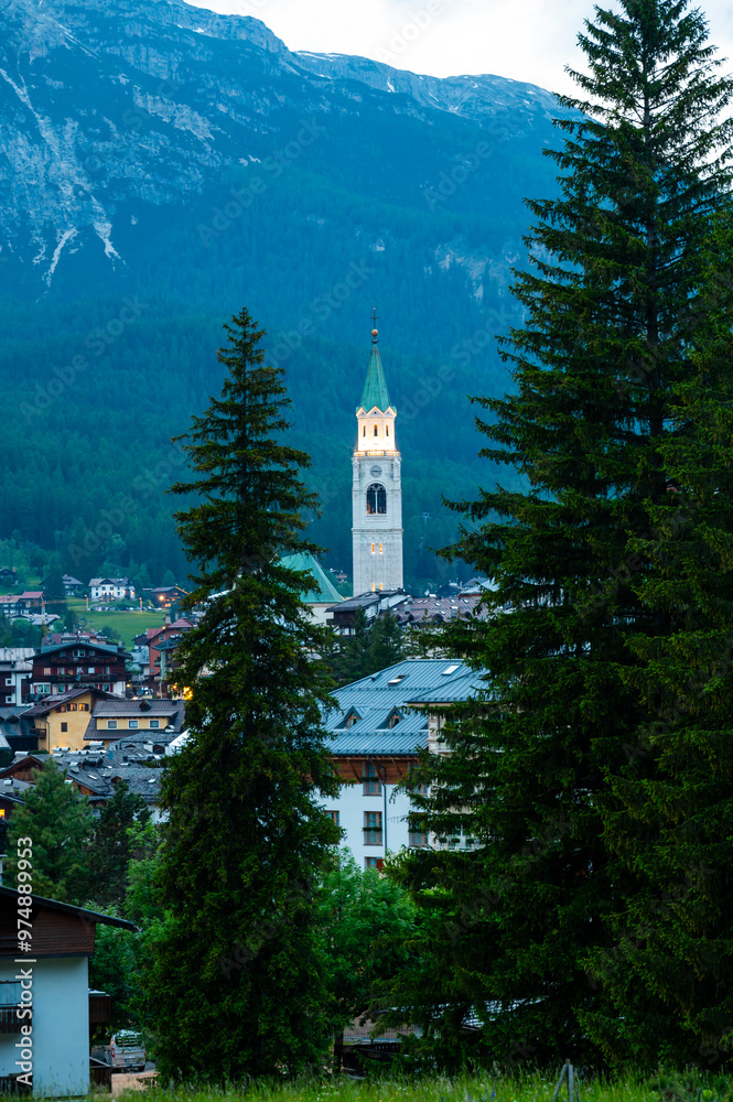 A view of the iconic church tower in the heart of Cortina d'Ampezzo. The architectural beauty of the tower stands tall against the backdrop of the surrounding Alpine scenery