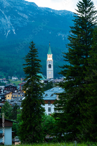 Obraz na płótnie A view of the iconic church tower in the heart of Cortina d'Ampezzo. The architectural beauty of the tower stands tall against the backdrop of the surrounding Alpine scenery w salonie