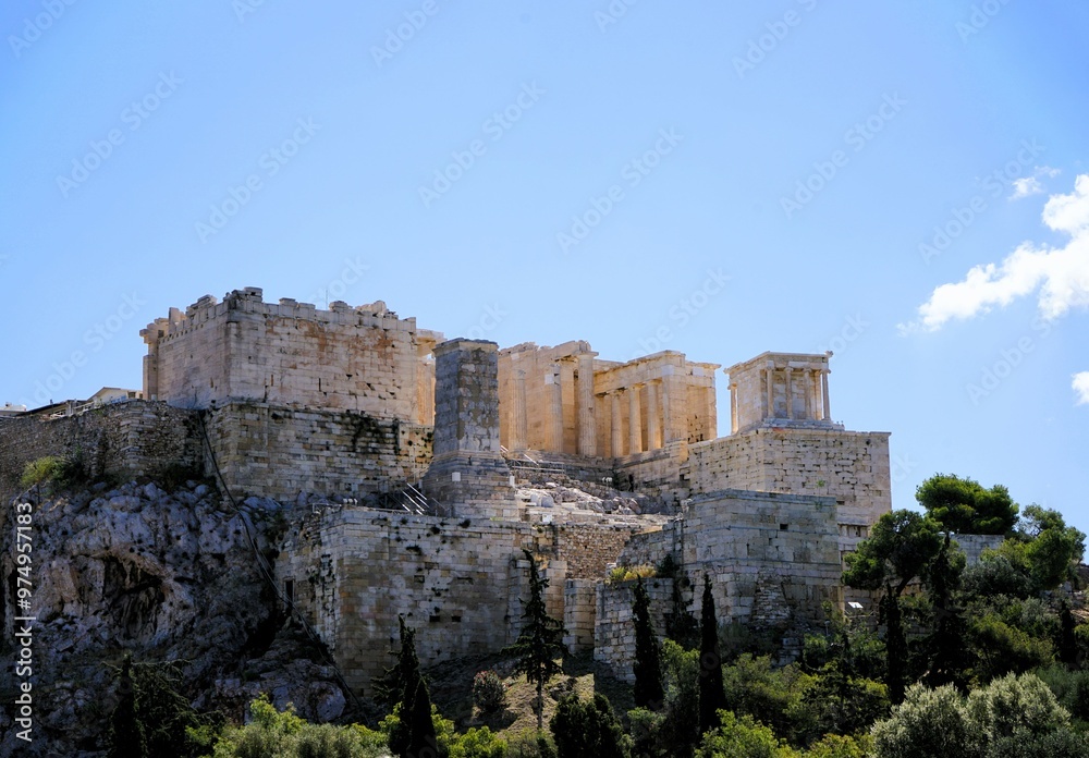 Fototapeta premium Panoramic view over the Acropolis and the temple of the Parthenon with a tall green cypress tree in the foreground in Athens, Greece, Europe.