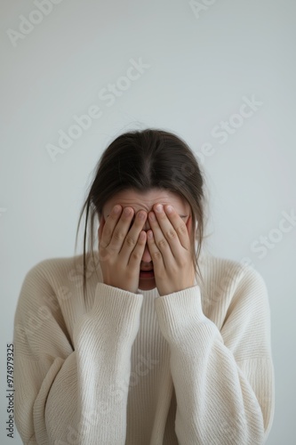 Woman covering her face with her hands, feeling emotional distress or tension