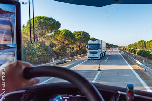 View from inside a truck on a highway with cones separating the two lanes for two-way traffic, transfer. photo