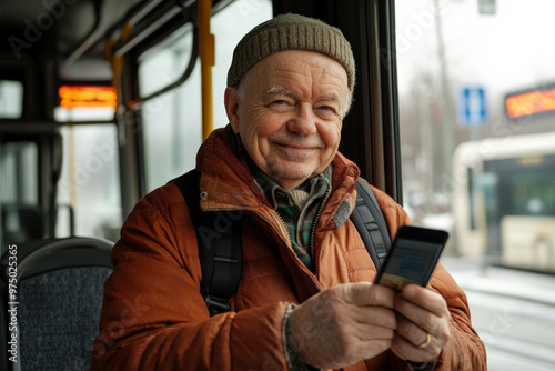 Obraz na płótnie A senior Caucasian man, smiling as he uses his mobile phone to pay for bus fare, standing confidently near the bus driver. w salonie