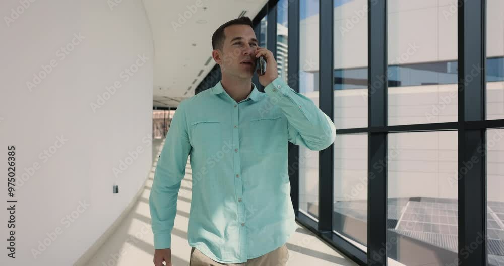 Successful confident large business owner man talking on mobile phone, making call, speaking on cell, discussing job communication, project, walking in contemporary office building hall Successful confident large business owner man talking on mobile phone, making call, speaking on cell, discussing job communication, project, walking in contemporary office building hall