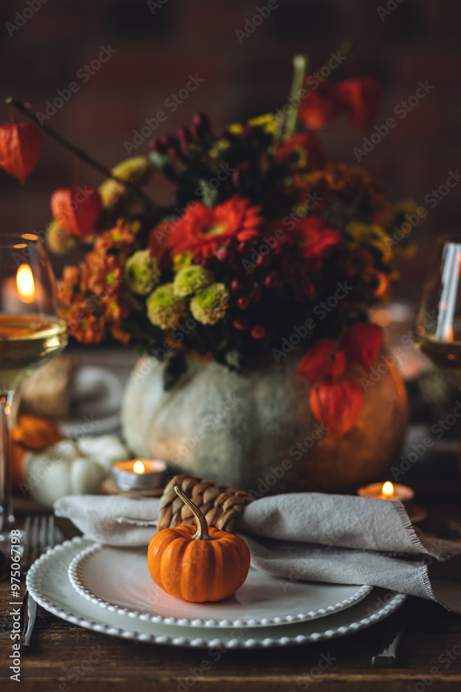 Fototapeta premium Fall composition. Orange pumpkins, flowers and candles on wooden table. Family elegant Thanksgiving or halloween dinner. Cozy autumn concept, simple handmade decoration, countryside style, wine