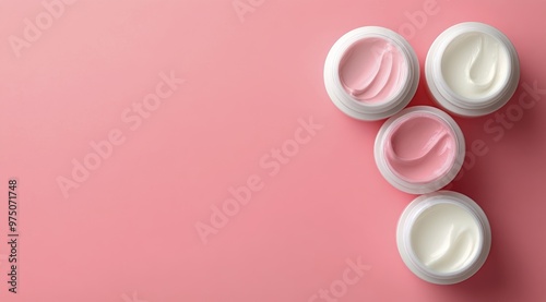 Colorful cream jars arranged on a pink backdrop showcasing skincare products ...