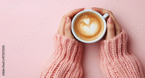 A cozy moment with a warm cup of latte art against a pastel pink background