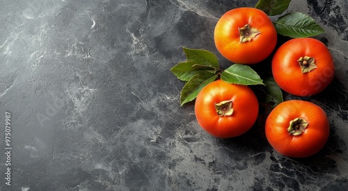 Freshly harvested citrus fruits on a textured stone surface in a dimly lit ki...