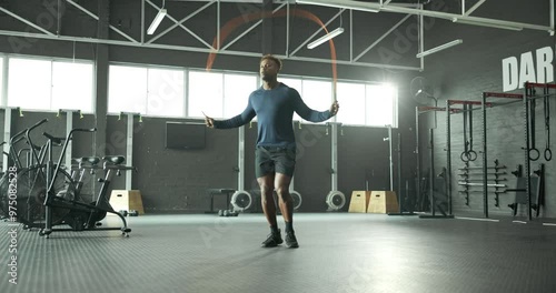 Jump, skipping rope or black man in gym for fitness for body health, training or cardio exercise in challenge. Development, agility or male African athlete with wellness, mobility workout or energy photo