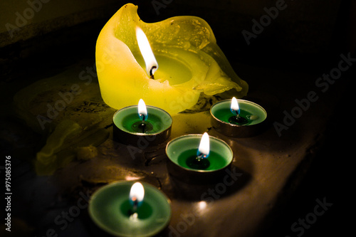 light green candles burning ritual offering to goddess saraswati indian culture diwali holiday wisdom knowledge wealth prosperity meditation spirituality and rituals religious services selling candles photo