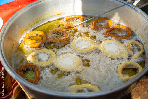 Frying a traditional Turkish donut ring dessert (Halka tatlısı) before dipping it in sugar syrup photo
