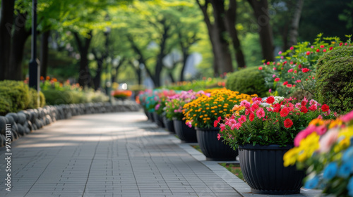 Wallpaper Mural A park pathway adorned with a row of colorful flowers in pots, creating a vibrant and inviting outdoor space. Torontodigital.ca