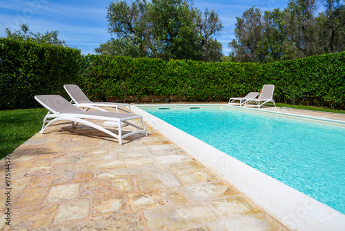 Poolside relaxation lounge chairs and privacy hedge