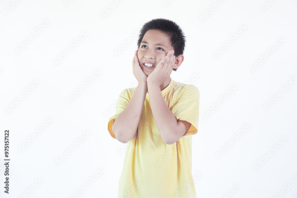 Boy wearing yellow tshirt smiling and holding cheeks. isolated on white background Boy wearing yellow tshirt smiling and holding cheeks. isolated on white background