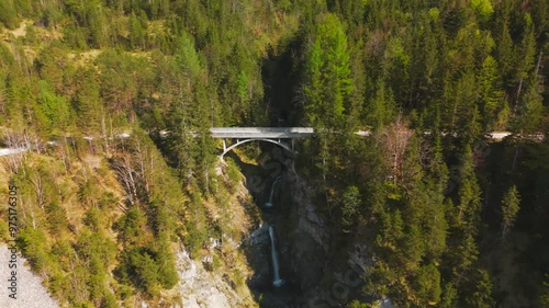 Luftaufnahme Schurpfen Wasserfall. Aerial view of crooked waterfall Schurpfen and bridge in gorge with forested mountain and canyon near Sylvensteinspeicher in Lenggries. Drone view falls and bridge.  photo