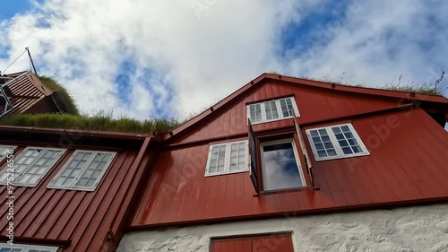 Scandinavian Style Buildings Against a Blue Cloudy Sky in Tórshavn, the capital city of the Faroe Islands Natural grass rooftops. Part of Tinganes - the historic location of the Faroese  government.