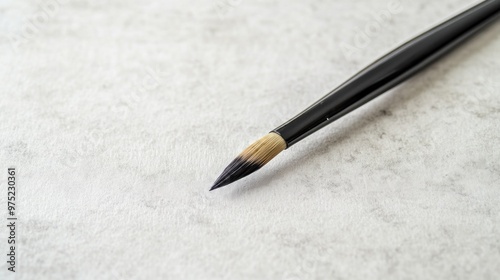 A close-up of a paintbrush on textured paper, ready for artistic creation.