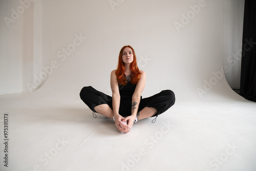 Portrait of a beautiful young red-haired girl in a studio.