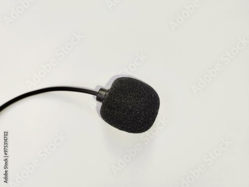 A small microphone covered with black foam on a white background